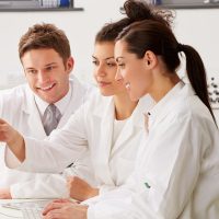 Group Of Scientists Checking Laboratory Results On Computer Group Of Scientists Checking Laboratory Results On Computer