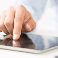 Close up of male hand using digital tablet Close up of male hand using digital tablet